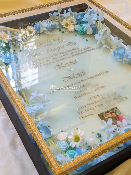 This custom wedding Kankotri features a beautiful blue and white floral theme. The resin has a subtle shimmer, and the invitation is presented in a premium box with a gold border.