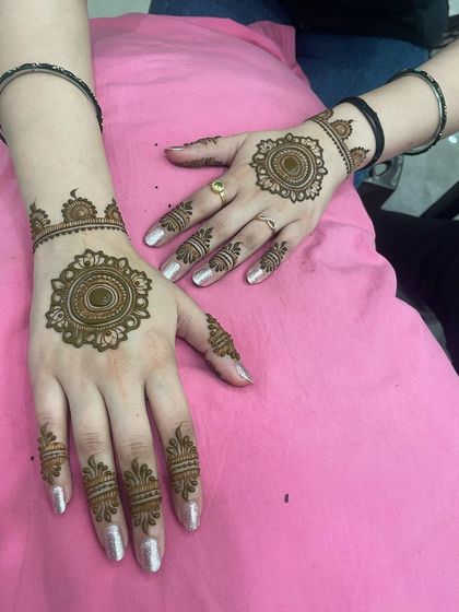Both hands adorned with a simple and elegant mandala design. This is a popular choice for guests and bridesmaids.