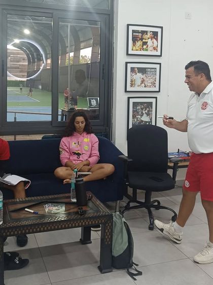 A coach passionately explains a mental concept to our players, who are seated and fully engaged in the session.