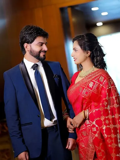 A candid moment between the couple at their engagement party. They are dressed in elegant formal wear, sharing a look of love.