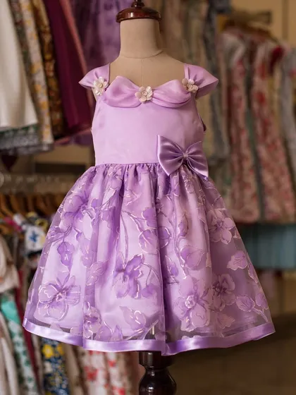 A gown fit for a little queen in a lovely shade of lavender. I used sheer, floral-patterned organza over a satin base and added delicate floral details at the collar to create this regal look.