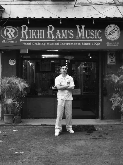 My heart, my roots. Standing outside the Rikhi Ram's Music store in Gole Market, Delhi. This is my family's legacy, handcrafting musical instruments since 1920, and it is the foundation of everything I do.