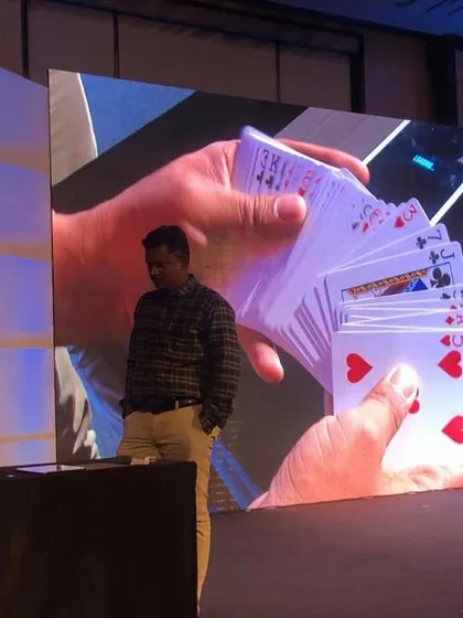 My stage shows are designed to be a visual spectacle. Here I am during a performance for a 'Rising Star' event, where a live camera feed projects my intricate card work onto the main screen, ensuring even the back row experiences the magic up close.