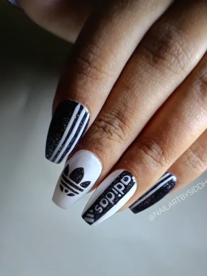 For the sports-lover, this set features the iconic Adidas logo and three stripes, hand-painted with a glittery black polish.