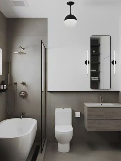 A minimalist bathroom featuring a freestanding bathtub and a glass-enclosed shower. The neutral grey tones and simple fixtures create a calm and serene environment.