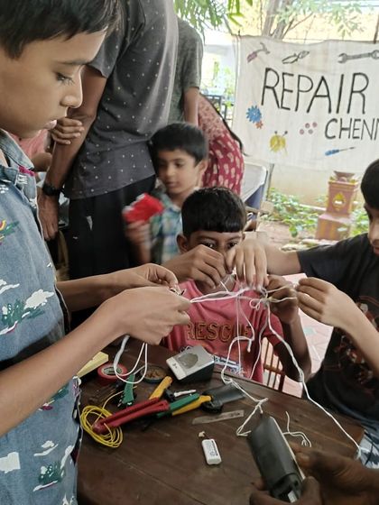 A group of kids get tangled up in wires and fun as they learn about circuits and electrical connections. Our workshops are designed to be playful and engaging, making learning about electronics an exciting adventure.