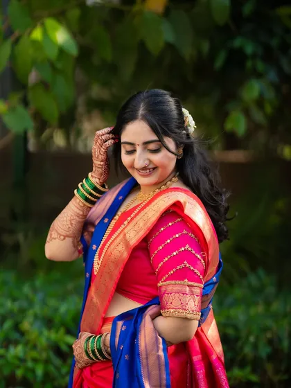A lovely solo portrait of the bride, Jagruti, showcasing her stunning saree, hairstyle, and joyful expression.