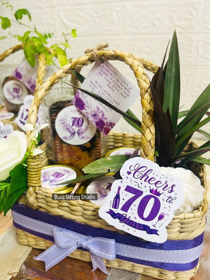 A close-up of the 70th birthday hamper, showing the personalized card and the mix of edible treats and a keepsake planter.