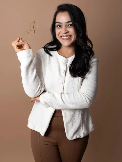 Adding a simple prop like glasses can add another layer to a professional headshot. It lends an intellectual and approachable feel to the portrait, making it perfect for an author, consultant, or academic who wants to appear both friendly and expert.
