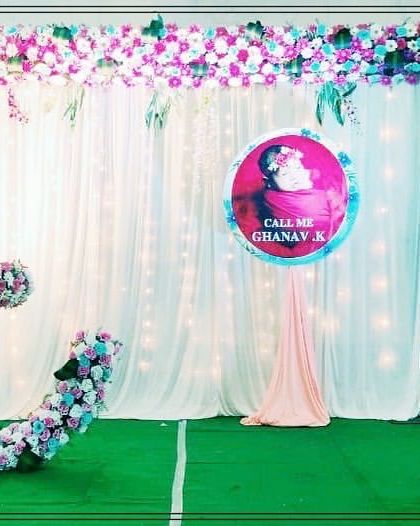 This naming ceremony setup features a crescent moon cradle decorated in pastel blue and pink flowers. A personalized name reveal sign makes the moment even more special for the family.