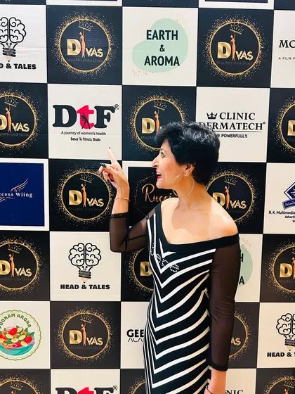 Proudly pointing to the DtF logo on the sponsor wall at the Delhi Divas beauty pageant.
