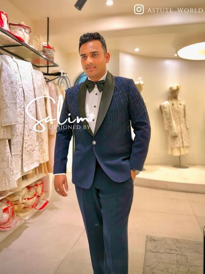 A client in my studio wearing a navy blue tuxedo with a subtle, sparkling grid pattern on the jacket. It's a modern design that adds texture and shine without being overwhelming.