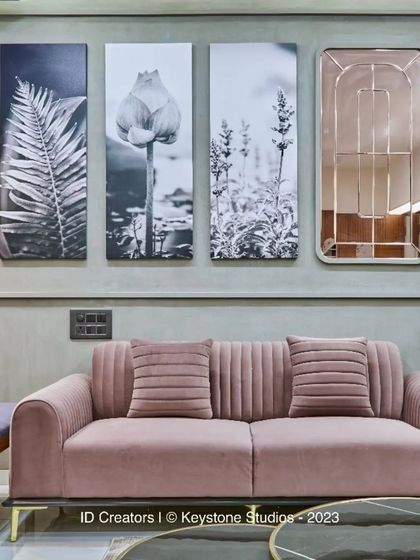 The composition of the living room wall, with its symmetrical arrangement of art and mirrors, creates a sense of balance and harmony.