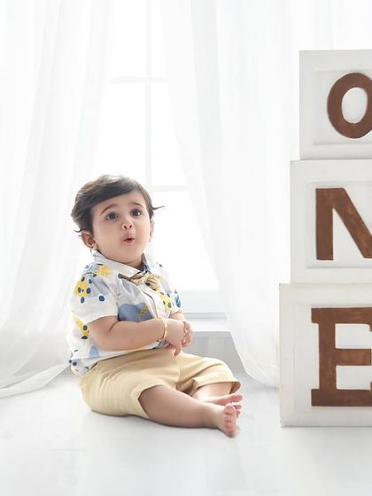 A simple and classic first birthday portrait. The stacked "ONE" blocks and clean, bright background create a timeless look.