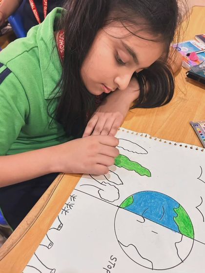 A student carefully colors a poster for the Earth Day competition. We encourage attention to detail and thoughtful expression in all our art-based projects.