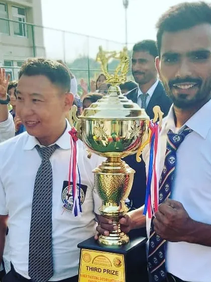 Celebrating a team victory with a third-prize trophy from a 2019 tournament. Every win, big or small, is a result of the entire dojo's collective effort.