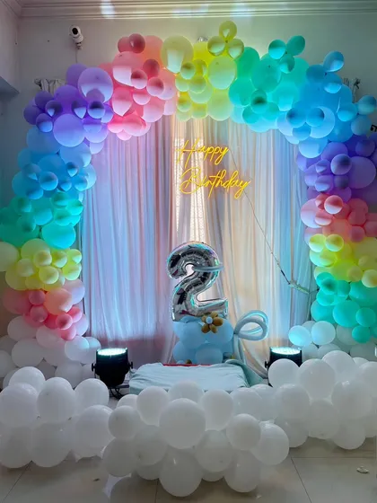We love creating vibrant and joyful setups. This rainbow-themed balloon arch with cloud effects at the base is perfect for a colorful and happy second birthday party.