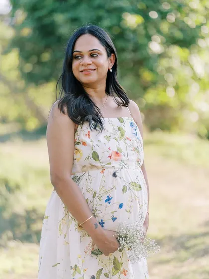 A lovely three-quarter portrait of the mother-to-be holding a small bouquet. The soft, blurry background keeps all the attention on her and her radiant expression.