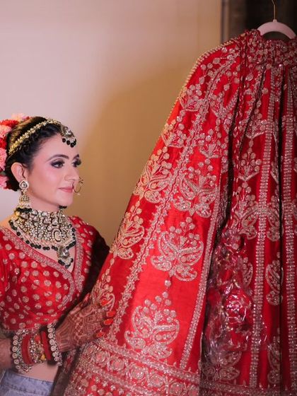 A beautiful moment where the bride looks at her wedding lehenga, a symbol of her big day.