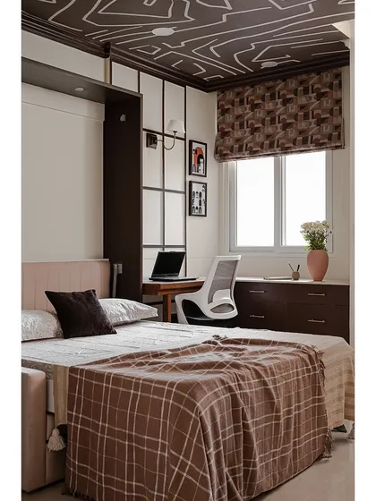 The same studio room with the Murphy bed pulled down. This space-saving solution allows the room to function as both a comfortable bedroom and a practical home office without feeling cluttered.