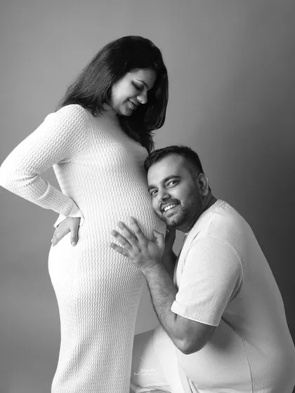 "I think I can hear something!" A classic and heartwarming pose where the dad to be listens to the baby bump, his smile showing the excitement for the adventure ahead.