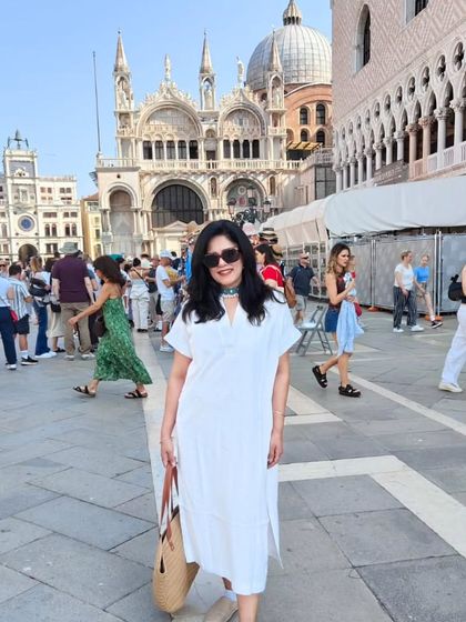 A full view of my outfit against the stunning backdrop of St. Mark's Square. This breezy white dress and my trusty jute bag were my companions for a day of exploring.