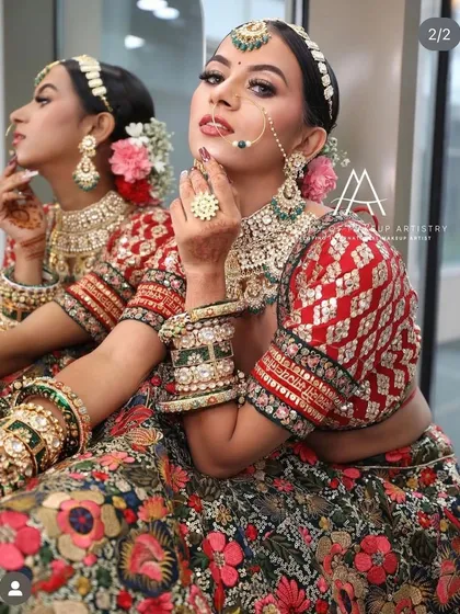A close-up of a bride in a floral lehenga, with a mirror reflection showing another angle of her look.