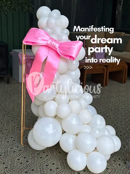 Manifesting your dream party into reality. This elegant white balloon sculpture with a big pink bow is a great example of how we can create a simple yet stunning statement piece.