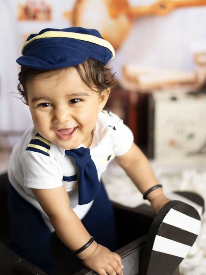 The cutest pilot you'll see today. Our pilot theme comes with a uniform, hat, and a wooden airplane prop for your little one to "fly".