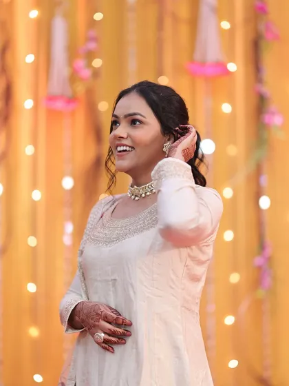 A candid, happy shot of a bridesmaid. Her makeup is soft and fresh, with a simple ponytail hairstyle that is both elegant and comfortable for a long day of celebrations.