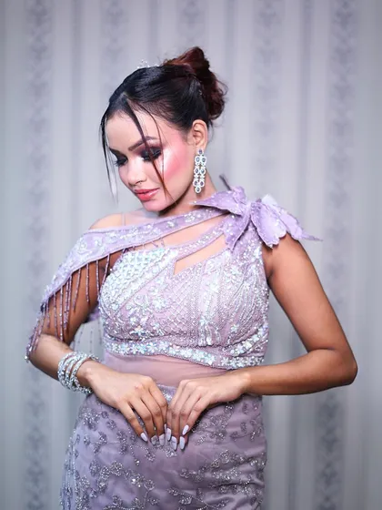 This lilac fish-cut gown with a ruffled trail is a modern masterpiece. The unique shoulder detail makes it a standout piece.