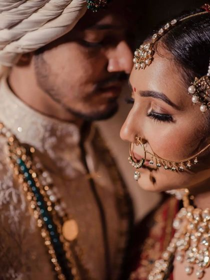 An intimate black and white close up of a bride and groom. This portrait focuses on the bride's serene expression and intricate nath (nose ring).