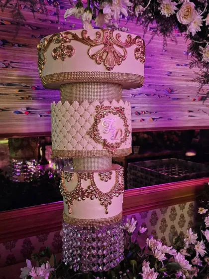 A close-up of the intricate gold baroque details and quilted pattern on the chandelier cake.