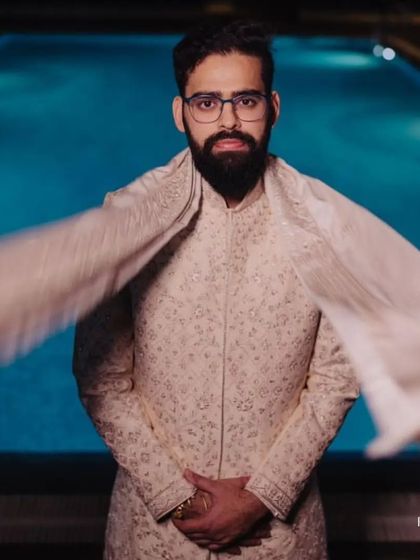 A dramatic shot of our client, the wind catching his stole. He wears a classic ivory sherwani, looking every bit the modern maharaja on his special day.