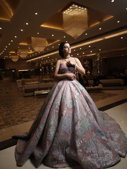 A wide shot of the metallic ball gown in a luxurious hotel lobby, showcasing its impressive volume and unique shimmer under the chandeliers.
