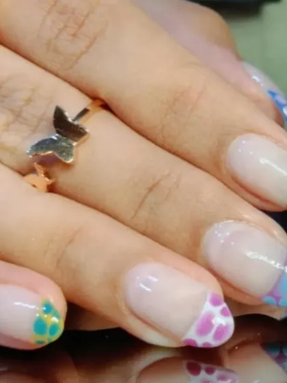 Another angle of the multi-colored spotted French manicure, showing how each nail has a different vibrant pattern.
