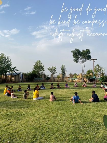 Children sitting in a circle on the grass, learning the core values of yoga: "be good, do good, be kind, be compassionate." Our retreats aim to nurture not just the body, but also the character.