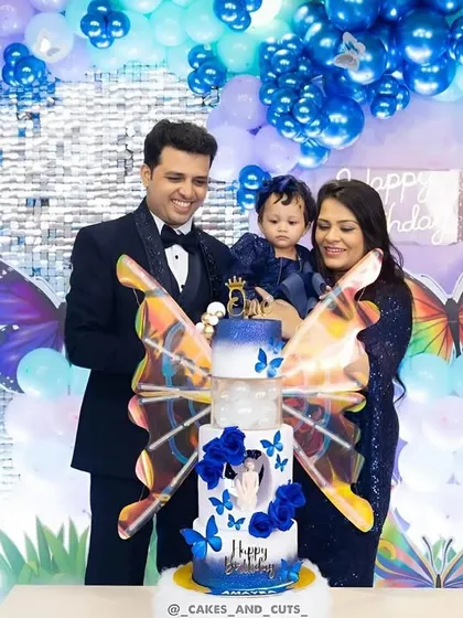The family cuts the stunning blue butterfly cake together, a beautiful moment from Amayra's birthday.