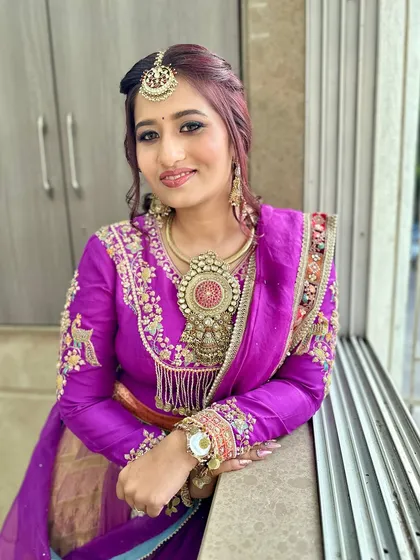 A close-up of this stunning purple look, showcasing the intricate jewelry and the flawless makeup.