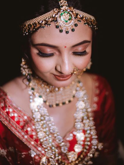 A close-up of the bride's flawless eye makeup and the intricate details of her matha patti.