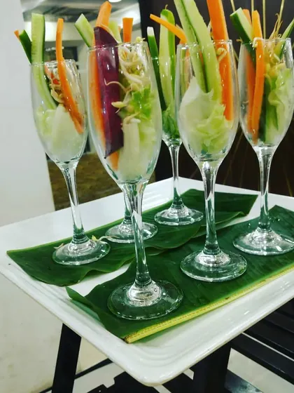 Fresh vegetable sticks and sprouts elegantly arranged in champagne flutes, a healthy and stylish appetizer for any modern event.
