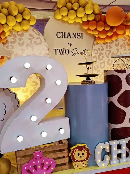 A close-up of the "Two Sweet" jungle theme, showing the light-up number '2' and custom-printed plinths with giraffe and sheep details.