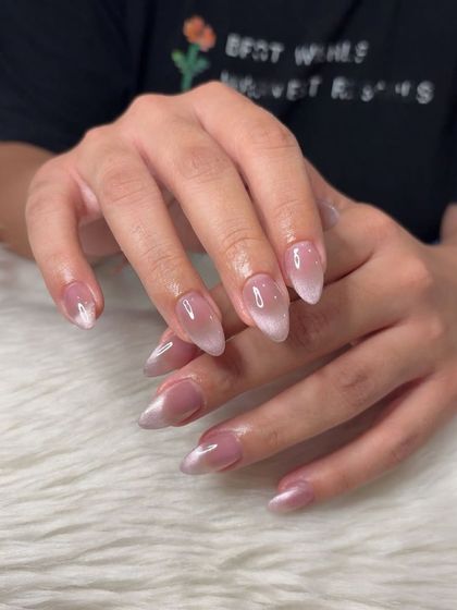 A soft and dreamy pink cat eye effect on almond-shaped nails.