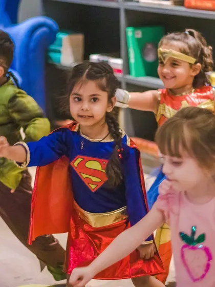 Supergirl leading the charge. Group activities in our superhero-themed class encourage teamwork and confidence.