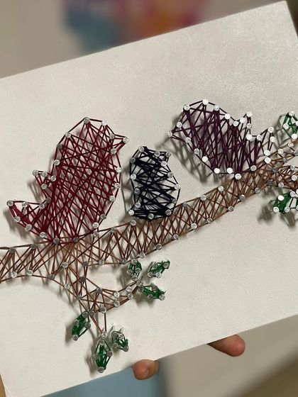A close-up of the "Family of Birds" string art, showcasing the detailed weaving and color choices.