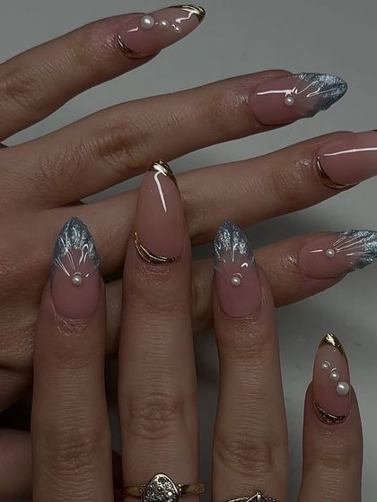A stunning "mermaid core" set with long stiletto nails, 3D silver shell-like tips, and pearl accents.