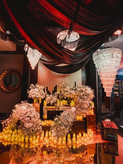 A dramatic photo spot with cascading white florals and hundreds of candles. We design these spaces to be not just beautiful, but interactive and memorable for guests.