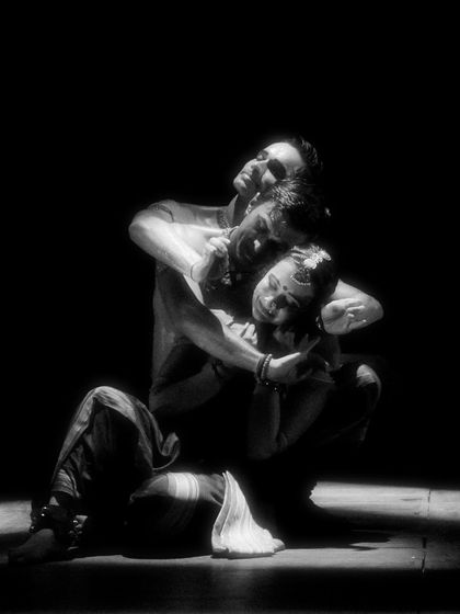 A black and white photo capturing a moment of embrace and support in 'Nagamandala'. This highlights the human relationships at the core of the mythological story.