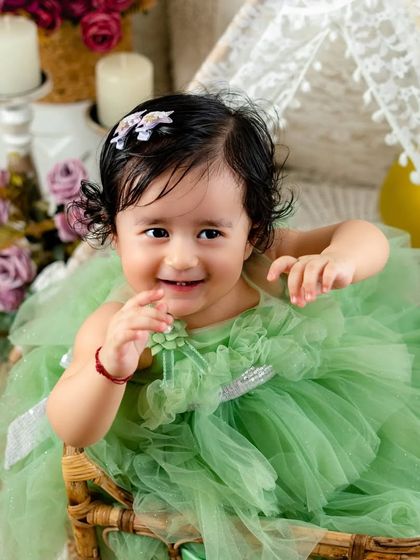 Giggles, curls, ribbons, and bows. This baby girl is adorable from head to toe, and her happy smile is the best part.