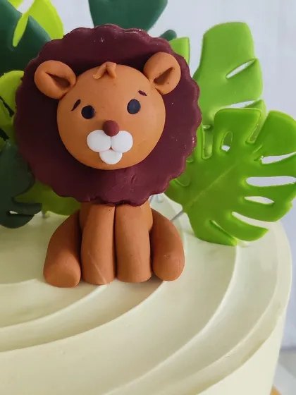 A close-up of the handcrafted fondant lion topper. I pay close attention to every detail to bring these little characters to life and add a touch of personality to your child's cake.
